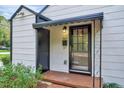 Charming home entrance with a black framed glass door and a covered porch, showcasing the property's curb appeal at 829 Colleton Rd, Raleigh, NC 27610