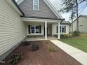 Charming home featuring a covered front porch with stone accents and a landscaped yard at 104 Roma Gora Ct, Princeton, NC 27569