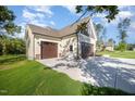 Attached two-car garage featuring a concrete driveway and lush landscaping at 104 Roma Gora Ct, Princeton, NC 27569