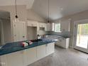 Modern kitchen featuring white cabinets and an island with blue countertops at 104 Roma Gora Ct, Princeton, NC 27569