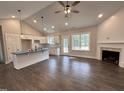 Open concept living area featuring hardwood floors, a stone fireplace, and views of the kitchen at 104 Roma Gora Ct, Princeton, NC 27569