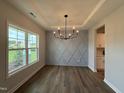 Bright dining room boasts a large window and a modern chandelier, creating an inviting atmosphere for meals at 105 Tuskeegee Dr, Smithfield, NC 27577