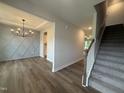 Elegant entryway with wood flooring, modern chandelier, decorative wall and staircase leading to upper level at 105 Tuskeegee Dr, Smithfield, NC 27577