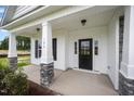 Inviting front porch with stone-based columns and a stylish black door, perfect for welcoming guests at 105 Tuskeegee Dr, Smithfield, NC 27577