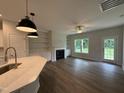 Open concept living room with a cozy fireplace, built-in shelves and an eat-in kitchen island with modern fixtures at 105 Tuskeegee Dr, Smithfield, NC 27577