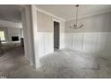 Elegant dining room with wainscoting and modern chandelier at 106 Roma Gora Ct, Princeton, NC 27569
