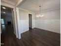 Spacious dining room features elegant wainscoting, dark wood floors, and a modern chandelier at 106 Roma Gora Ct, Princeton, NC 27569