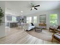 Bright open-concept living room with lots of natural light, modern decor, and an adjacent gray kitchen at 112 Remington Woods Dr, Wake Forest, NC 27587