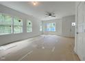 Bright, spacious living room features large windows and a modern ceiling fan at 112 Remington Woods Dr, Wake Forest, NC 27587