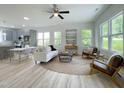 Bright, open-concept living area with lots of natural light, ceiling fan, and modern furnishings at 112 Remington Woods Dr, Wake Forest, NC 27587