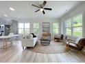 Bright, open-concept living area with lots of natural light, ceiling fan, and modern furnishings at 112 Remington Woods Dr, Wake Forest, NC 27587