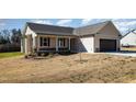 Inviting single-story home with a covered front porch and a well-maintained lawn at 122 Wilderness Trl, Smithfield, NC 27577