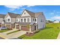 Charming two-story townhome with brick accents, a two car garage, and a well-manicured lawn in a vibrant community at 125 Paperwhite Pl, Clayton, NC 27527