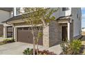 Side view of a new construction townhouse with a brick facade, two-car garage and professional landscaping at 125 Paperwhite Pl, Clayton, NC 27527