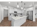 Bright kitchen featuring white cabinets, a large island, stainless steel appliances, and stylish pendant lighting at 125 Paperwhite Pl, Clayton, NC 27527