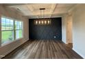 Bright dining room featuring modern light fixture, coffered ceiling, and paneled wall at 125 Tuskeegee Dr, Smithfield, NC 27577
