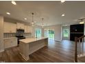 Open concept kitchen featuring white cabinets, stainless steel appliances, and a kitchen island at 125 Tuskeegee Dr, Smithfield, NC 27577