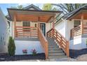Charming home featuring a covered porch with wooden railings, and well manicured landscaping, creating a welcoming curb appeal at 13 St Augustine, Raleigh, NC 27610
