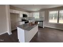 Bright kitchen featuring white cabinets, granite countertops, and stainless steel appliances at 131 Wilderness Trl, Smithfield, NC 27577