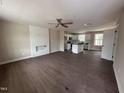 Open-concept living space with hardwood floors and a view of the modern kitchen with island at 131 Wilderness Trl, Smithfield, NC 27577