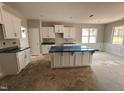 Kitchen area featuring white cabinets, granite countertops, and a center island with room for seating at 139 Red River Dr, Selma, NC 27576