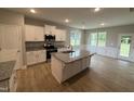 Well-lit kitchen with white cabinetry, granite countertops, a center island, and stainless steel appliances at 139 Red River Dr, Selma, NC 27576