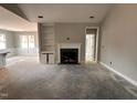 Living room showcasing a fireplace, built-in shelving, and an open floor plan to the kitchen at 139 Red River Dr, Selma, NC 27576