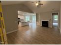 Spacious living room featuring hardwood floors, a fireplace, and an open layout into the kitchen at 139 Red River Dr, Selma, NC 27576