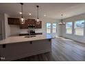 Gourmet kitchen with quartz countertops, pendant lighting, stainless appliances, and seamless flow into the dining area at 141 Trescott St, Smithfield, NC 27577