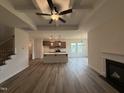 Elegant living space with fireplace, coffered ceilings, and an open view of the contemporary kitchen at 141 Trescott St, Smithfield, NC 27577