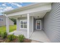 Inviting front porch with classic columns and a stylish gray front door at 147 Tuskeegee Dr, Smithfield, NC 27577