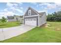 Spacious two-car garage with a gray exterior and long driveway at 147 Tuskeegee Dr, Smithfield, NC 27577