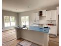 Bright kitchen with white cabinets, a large island, and stainless steel appliances at 147 Tuskeegee Dr, Smithfield, NC 27577