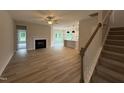 Open-concept living room with hardwood floors, a fireplace, and stairs to upper level at 147 Tuskeegee Dr, Smithfield, NC 27577