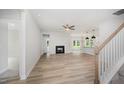 Open-concept living room featuring a fireplace, modern lighting, and wood floors at 147 Tuskeegee Dr, Smithfield, NC 27577