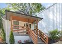 Exterior shot of a home with wooden porch and stylish railings, leading to a glass-paneled front door at 15 St Augustine, Raleigh, NC 27610