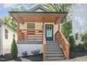 Charming home featuring a cozy front porch with wood railing and a welcoming green door at 15 St Augustine, Raleigh, NC 27610