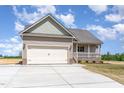 Single-Gathering home featuring a two-car garage, covered porch, and professional landscaping at 163 Royal Ave, Selma, NC 27576