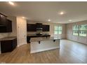 Modern kitchen featuring dark cabinets, granite countertops, stainless steel appliances, and a central island at 18 Bonnybrook Ct, Selma, NC 27576
