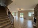 Bright, open living space features wood floors, stone fireplace, and sliding glass doors to backyard at 18 Bonnybrook Ct, Selma, NC 27576