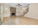 Spacious living room with a stone fireplace, hardwood floors, and staircase at 18 Bonnybrook Ct, Selma, NC 27576