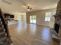 Spacious living room with wood floors, stone fireplace, ceiling fan and sliding doors to the outside at 18 Bonnybrook Ct, Selma, NC 27576
