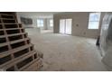 Spacious living room featuring large windows, unfinished hardwood floors and an open floor plan at 18 Bonnybrook Ct, Selma, NC 27576