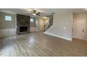 Spacious living room with built-in cabinets, a stone fireplace, wood flooring, and staircase access at 18 Bonnybrook Ct, Selma, NC 27576