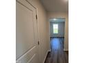 Hallway showcasing the wood flooring with a view of a brightly lit room at 18 W Emily Gardens Dr, Selma, NC 27576