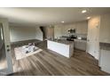 Spacious living area with hardwood floors adjoining kitchen with island and granite countertops at 18 W Emily Gardens Dr, Selma, NC 27576