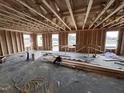 Spacious interior shows the home's wooden framing with ample natural light streaming through the window openings at 18 W Emily Gardens Dr, Selma, NC 27577