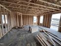The interior framing of the residence reveals an open floor plan with wooden support beams and window openings at 18 W Emily Gardens Dr, Selma, NC 27577