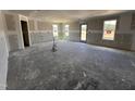 Large unfinished room with lots of natural light from several windows and a glass door at 18 W Emily Gardens Dr, Selma, NC 27577