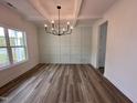 Bright dining room with a decorative wall, modern chandelier, and beautiful hardwood flooring at 21 Trescott St, Smithfield, NC 27577